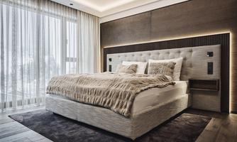 A modern bedroom with a large bed and a cozy blanket. Large windows provide plenty of daylight and an elegant look.