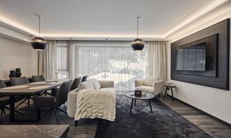 A modern living room with an elegant sofa and a glass table. Large windows let in plenty of light and provide a view of the surroundings.