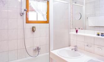 A modern bathroom with a bathtub and a shower. Two sinks and a large mirror are also present.