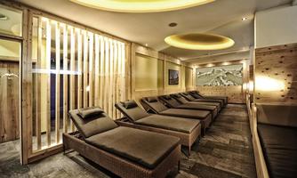 An elegant relaxation area with loungers and wood paneling. Soft lighting and a calm atmosphere invite you to relax.