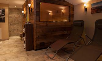 A cozy wellness area with a sauna and loungers. The warm colors create a relaxing atmosphere.