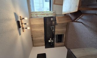 A modern kitchenette made of wood with a dining area. The kitchen is well-lit and offers a pleasant living space.