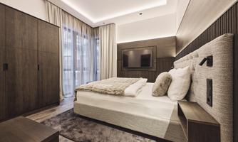 A modern bedroom with a comfortable bed and elegant wooden furniture. Large windows provide plenty of light and a pleasant atmosphere.