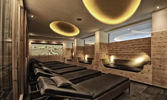 A relaxing wellness area with comfortable loungers and a modern, natural ambiance. The soft lighting creates a tranquil atmosphere.