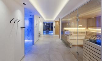 A modern spa area with soft lighting effects and a sauna. The room is bright and inviting, ideal for relaxation.