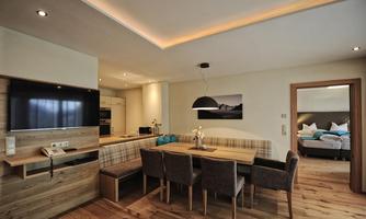 A modern apartment with an open living area. The room is bright and cozy furnished, with a dining table and a small kitchen.