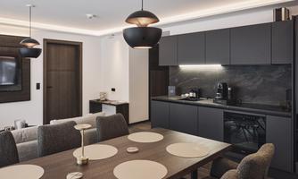 A modern kitchen with a large dining table and stylish furniture. The rooms are well-lit and feature an elegant color palette.