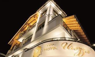 An elegant hotel building with a modern facade. The building is illuminated at night and exudes an inviting atmosphere.