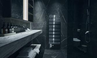 A modern bathroom with dark walls and an elegant marble sink. The lighting creates a stylish effect and a feeling of luxury.