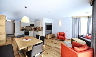 A modern apartment with an open living area. The space is bright and friendly, with a dining area and comfortable seating.