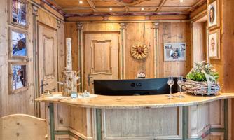 An inviting reception area made of wood with traditional details. The stage is decorated with flowers and pictures on the wall.