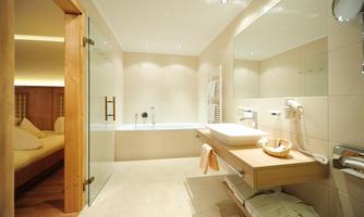 A modern bathroom with a glass shower and a freestanding bathtub. The walls are in neutral colors, and there are wooden accents.