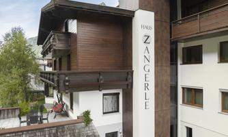 A modern house named "Zangerle" is in the foreground. It features an appealing facade with wooden and stylish elements.