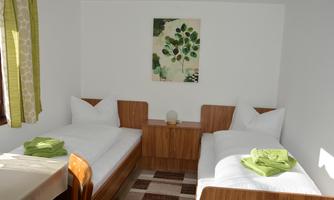 A cozy room with two single beds and wooden details. Fresh green towels are placed on the beds, and a piece of artwork adorns the wall.