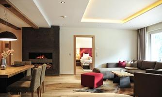 A modern living room with a cozy fireplace and stylish furniture. The room is bright and inviting, with hardwood floors and large windows.