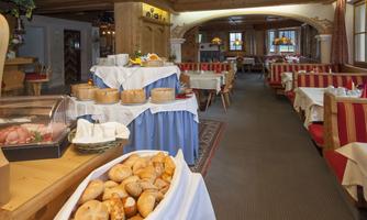 An inviting restaurant with rustic decor and cozy seating. Fresh bread and various dishes are arranged on a table.