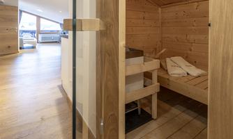 A modern sauna with wooden paneling and practical loungers. The room offers a relaxing atmosphere and plenty of natural light.