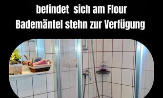 A modern bathroom with a shower and bright tiles. Bathrobes are also available.