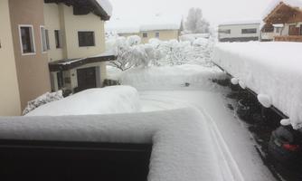 A snowy courtyard with high snow drifts. The surroundings are quiet and wintry.