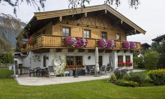 A charming wooden house with a balcony full of flowers. The well-maintained garden invites relaxation.
