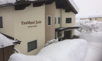A house in the snow, surrounded by a white winter landscape. The inscription "Landhaus Feidl" is clearly visible.