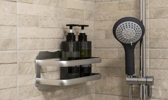 A modern shower area with a simple tiled wall. On a shelf are black bottles for shampoo and shower gel, next to a showerhead.