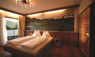 A modern bedroom with large windows and a view of the mountains. There are two beds, wood paneling, and stylish lighting.