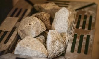 A pile of stones in a chimney system. The stones are coarse and lie on a stainless steel grid.