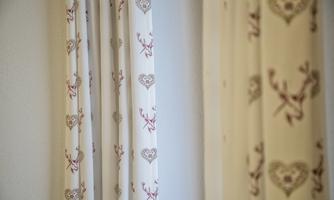 A pair of curtains with a cute heart and deer design. They are bright and fit well in a friendly room.