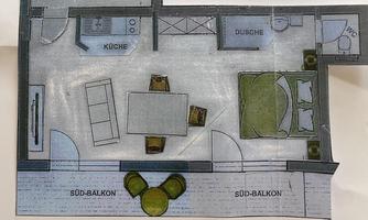 A floor plan drawing of an apartment with a living room, a kitchen, and a bedroom. There are two balconies and a dining area.