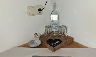 A decorative corner with a bottle of water, glasses, and a small figurine. A heart-shaped coaster completes the picture.