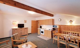 A cozy apartment with an open kitchen and a living area. The space is brightly lit and offers an inviting atmosphere.