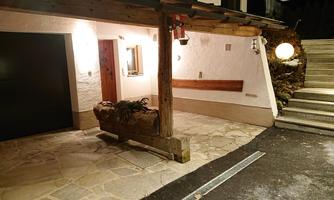 A cozy entrance with a stone floor and wooden details. Next to the front door, stairs lead upwards.
