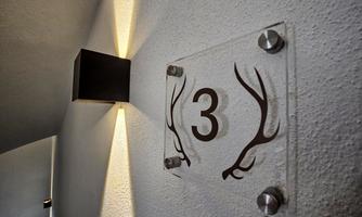 A wall sign with the number 3 and antlers in a modern design. The lighting enhances the sign.