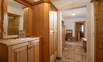 An inviting hallway with wooden cabinets and a tiled floor. The warm atmosphere creates a cozy impression.