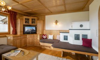 A cozy living space with wooden furniture and a television. The decor feels warm and inviting, perfect for relaxing.