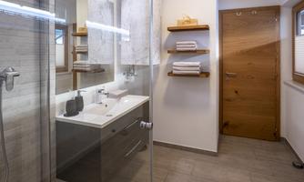 A modern bathroom with a shower and a bright, minimalist design. Shelves with towels create a pleasant atmosphere.