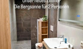 A modern bathroom with elegant tiles and a bright atmosphere. It is well-equipped and ideal for two people.