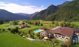A picturesque resort in the mountains with a large garden and a pool. Surrounded by green meadows and impressive mountains.