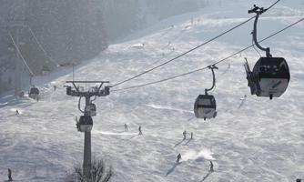 A ski jump landscape with snowy slopes and skiers. Cable cars glide over the wintry scene.