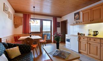 A cozy holiday apartment with wooden interiors. The kitchen is spacious and well-equipped, and the living area invites you to relax.