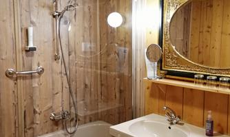 A modern bathroom with a bathtub and a shower. The wood look and the luxurious mirror give the room a cozy atmosphere.