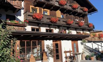 A traditional alpine house with blooming balcony boxes. The clear blue sky complements the idyllic atmosphere.