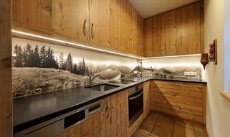 A modern kitchen with wooden cladding and an elegant granite worktop. In the background, a photorealistic landscape with mountains and trees is visible.