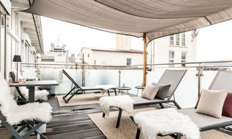 A stylish balcony with loungers and sun protection. The outdoor furniture provides a comfortable spot to relax.