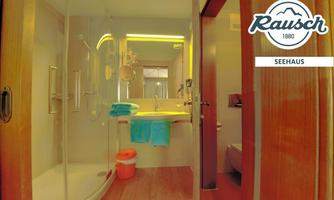 A modern bathroom with a shower cabin and a sink. Towels in bright colors are ready.
