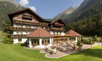 A cozy hotel in the mountains with an inviting restaurant area.  
Surrounded by greenery and beautiful nature.