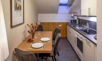 A modern kitchen with a dining area. The table is set and there is a pleasant atmosphere.