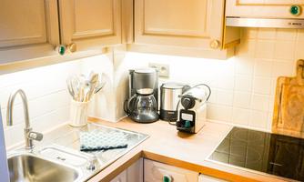 A cozy kitchen with bright cabinets and modern appliances. The room is well-lit and tidy.