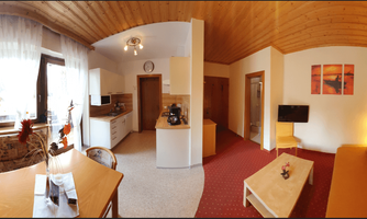 A bright and cozy apartment with an open-plan kitchen and an inviting living area. Large windows provide plenty of daylight and a warm atmosphere.